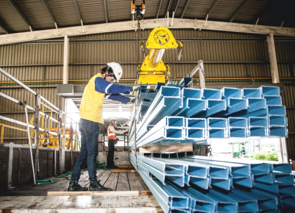 Worker adjusting metal beams in a warehouse
