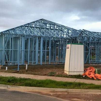AAA project: Exterior view of a blue steel frame house under construction